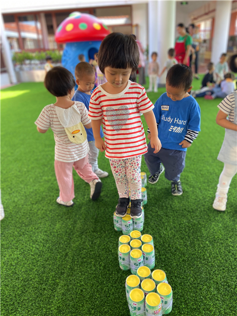 老师们将收集来的易拉罐自制成跨栏和梅花桩,让宝贝们锻炼跨,跳和平衡
